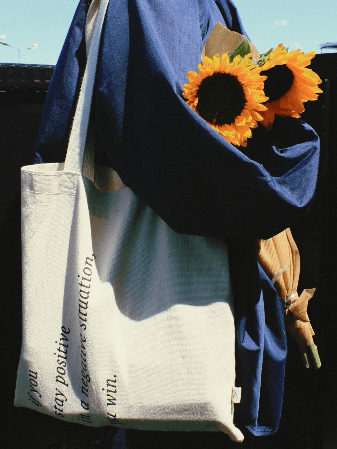 Stylish Woman Holding Sunflowers in Tote Bag